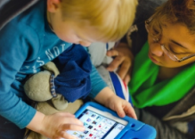 child and therapist on a tablet
